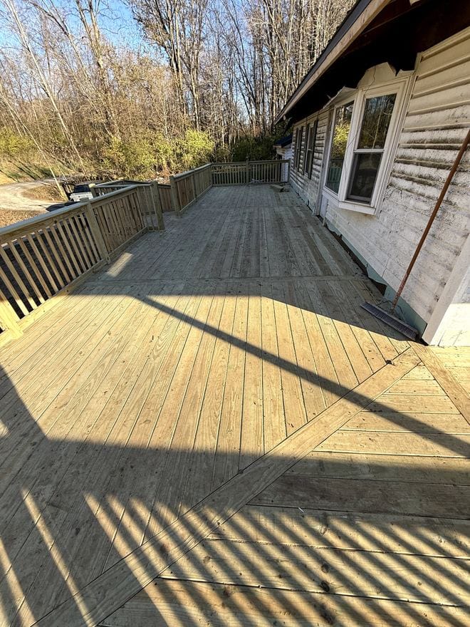 Finished treated wood deck behind a house